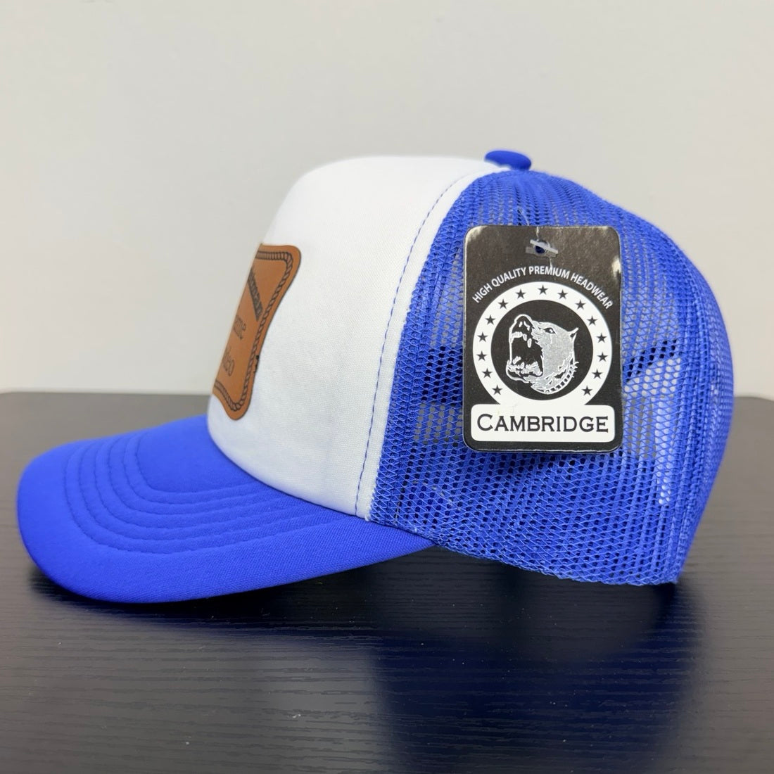 Cambridge royal blue mesh trucker cap, side view with manufacturer tag
